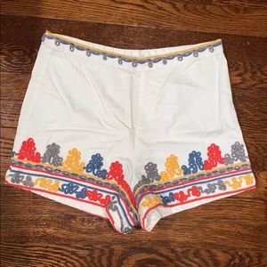 White canvas shorts with subtle colorful accents.